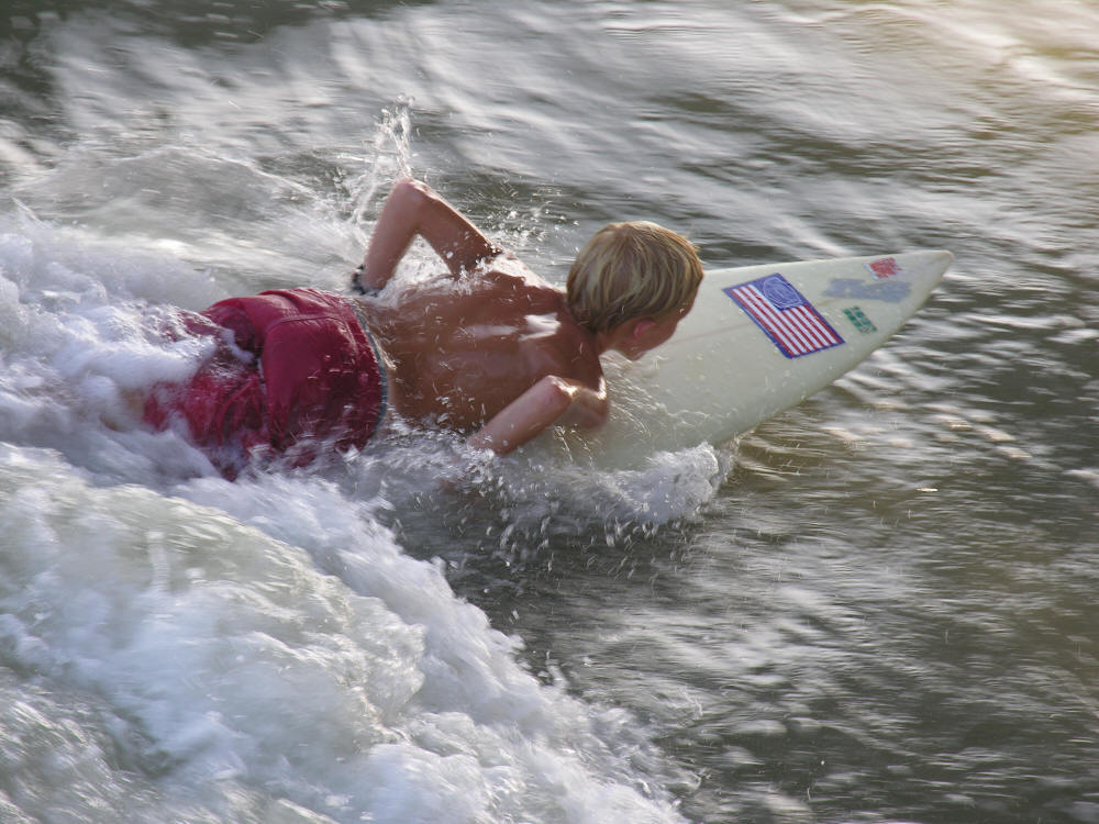 kid surfing surfer boy on surf board at the beach in the ocean in Florida