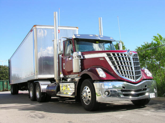 Burgundy - maroon International Lonestar day cab tractor with lots of chrome pulling Great Dane trailer