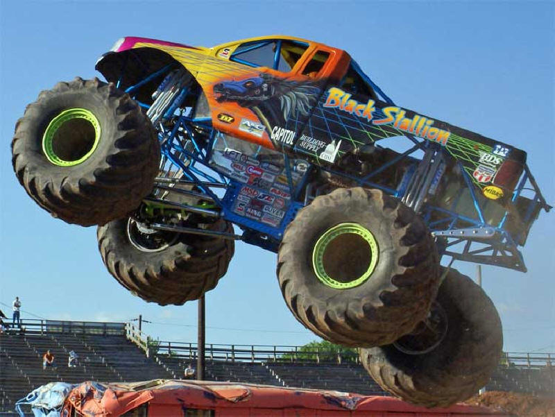 Black Stallion Monster Truck in the air showing struts and stuff