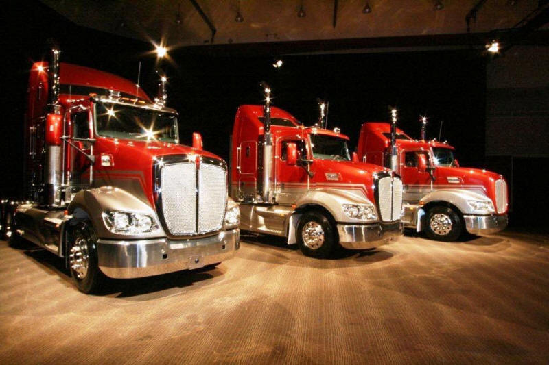 Three Kenworth trucks on the showroom floor