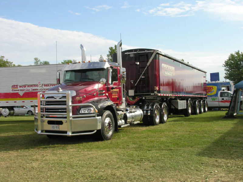 Picture of nice Red and Black Mack Truck with matching heavy duty trailer at truck show
